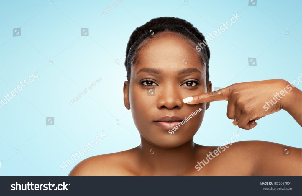 medcare vacances - stock photo beauty and people concept portrait of young african american woman with bare shoulders pointing 1830067904